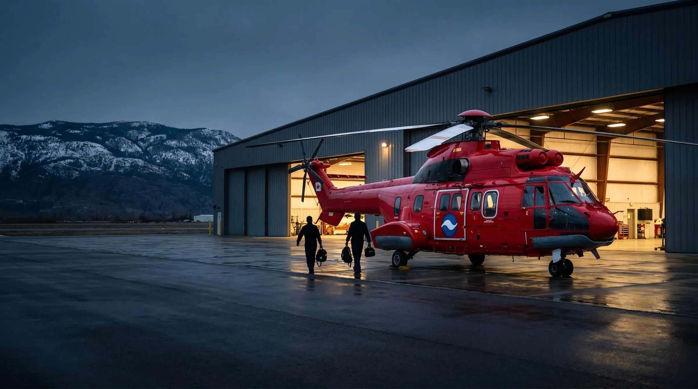 A red Coldstream Super Puma helicopter on the ramp outside the Kelowna hangar at dawn