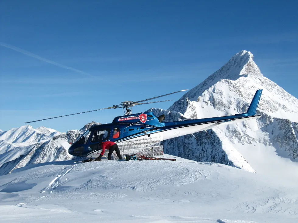 Airbus AStar staged on a mountain ridge during heli-ski operations
