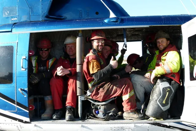 Seismic crew seated in a Coldstream Bell 212 cabin giving a thumbs up before liftoff