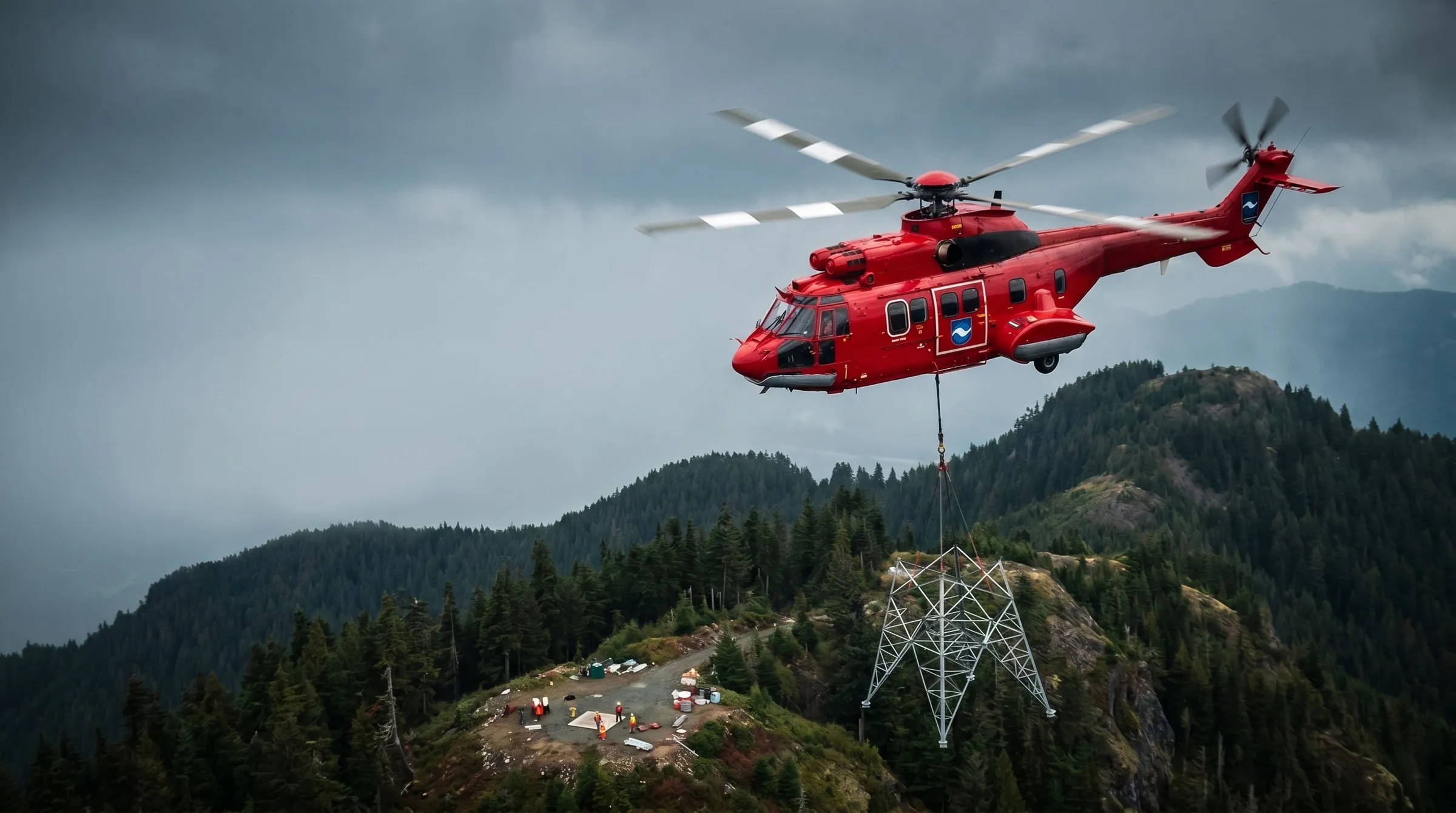 A red Coldstream Super Puma helicopter long-lining a steel tower section over a forested ridge