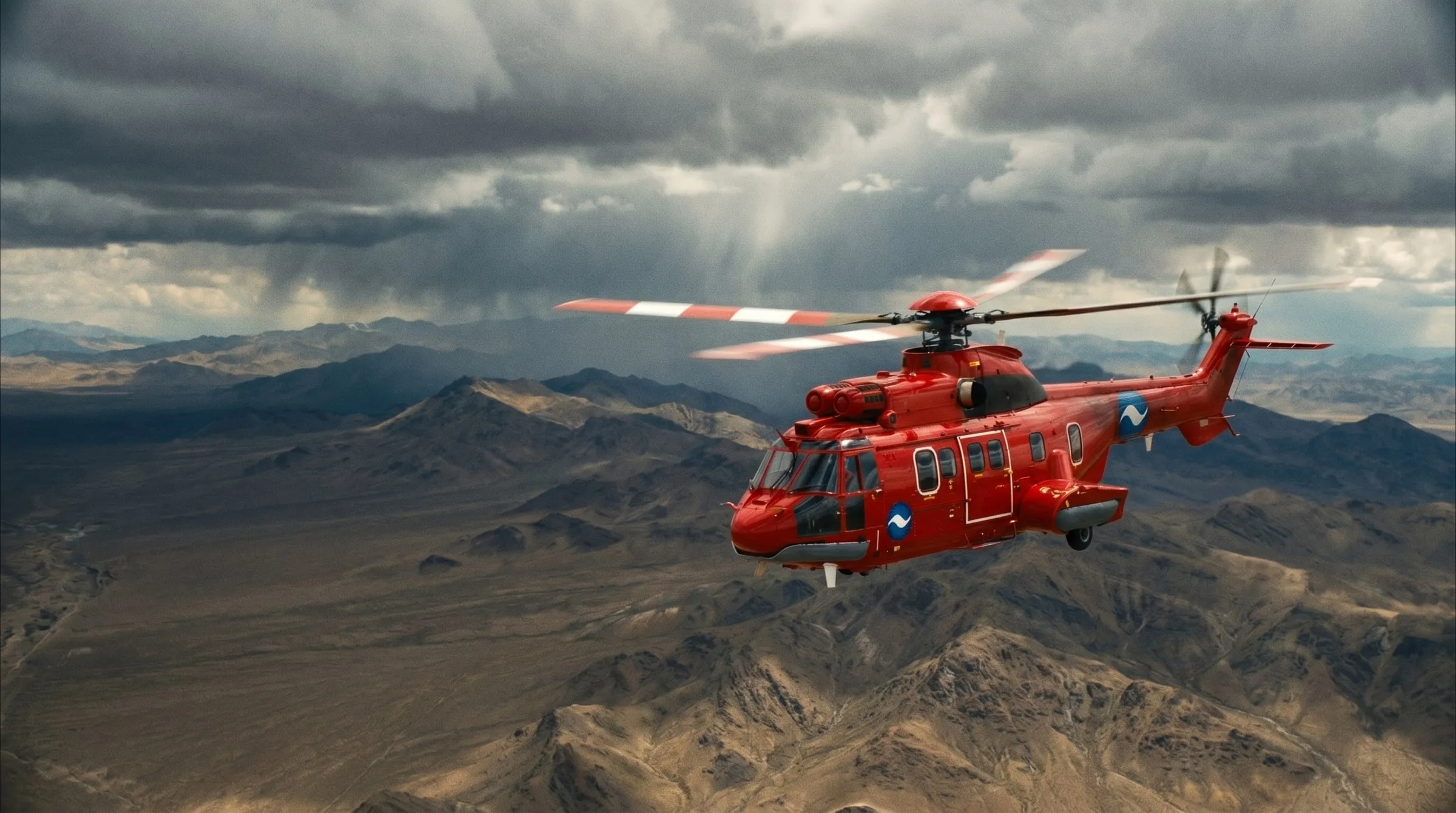 A red Coldstream Super Puma helicopter flying over rugged high-altitude desert mountains